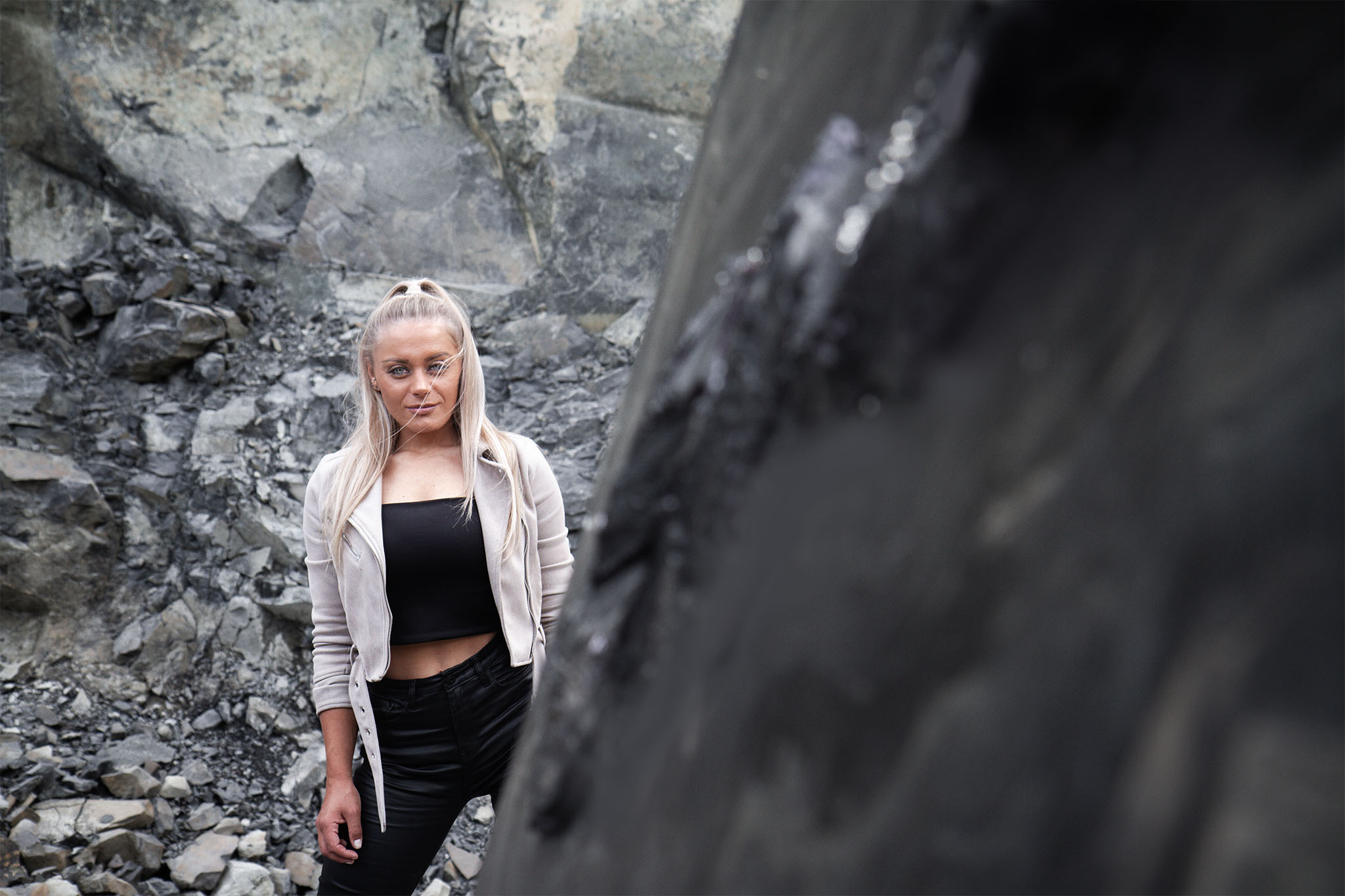 Jennit steht hinter einem grauem Kunstwerk ihrer Kunstserie Marbleous.