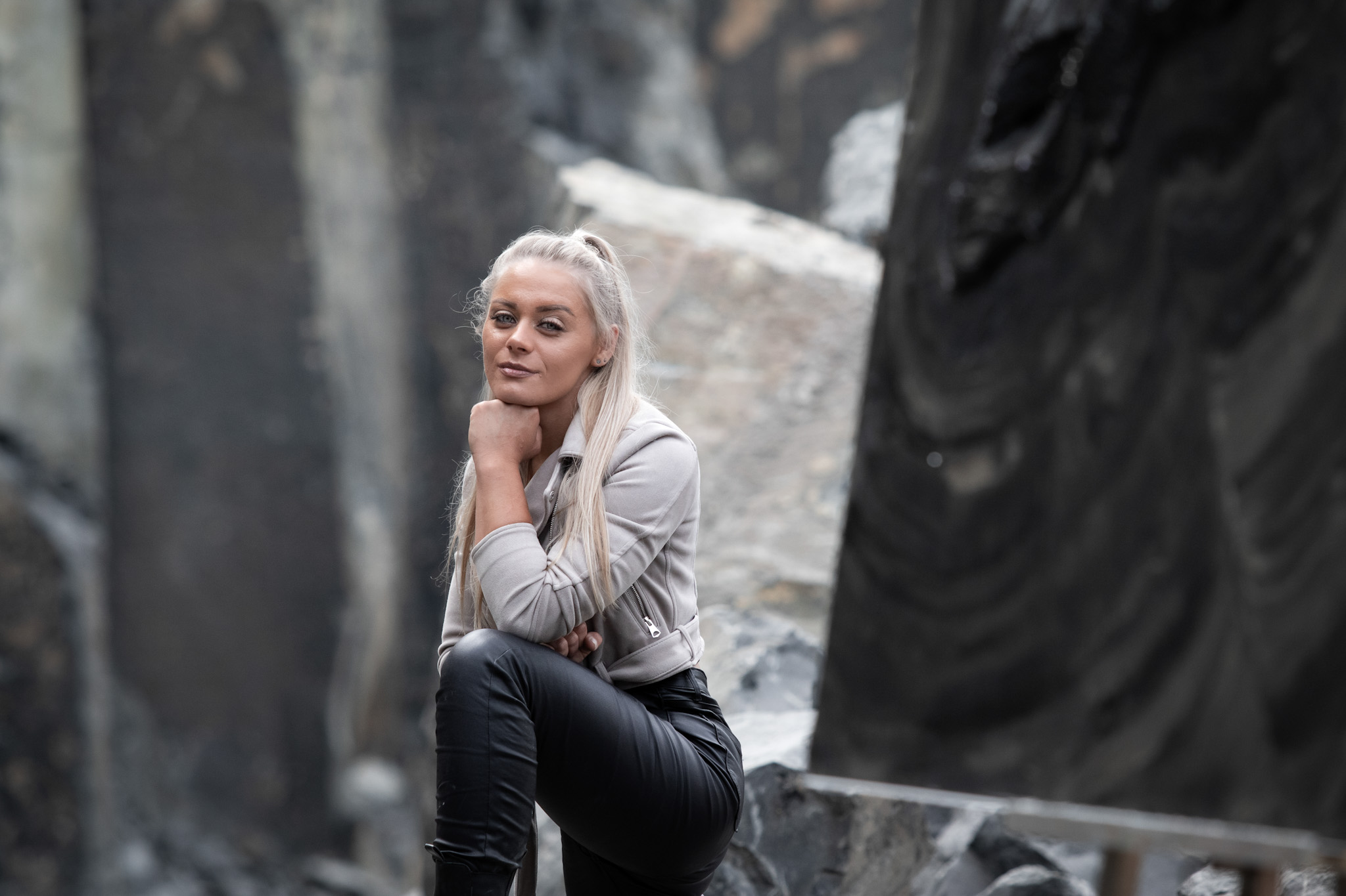 Ein Artist Foto der Künstlerin Jennit in einem Steinbruch in dem sie entschlossen leicht in die Kamera lächelt.